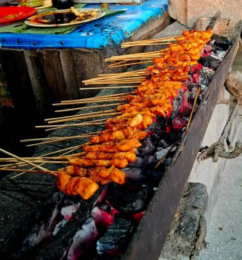 Geleneksel Endonezya yapımı kömür odunuyla ızgarada kızartılmış tavuk satay tabağı..
