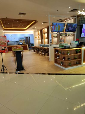 Surabaya - Endonezya, 22 Nisan 2025. Bay Meyve Suyu Restoranı 'nın önü, açık, çağdaş ve modern bir tasarım. Tablolar, sandalyeler ve diğer destekleyici öğeler çekici bir şekilde düzenlenmiştir.