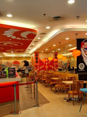 Surabaya - Endonezya, 22 Nisan 2025. Japon atmosferi, modern, ışık oyunu ve ilginç ahşap elementlere sahip Yoshinoya restoranının içi. Göz düzeyi görünümü.