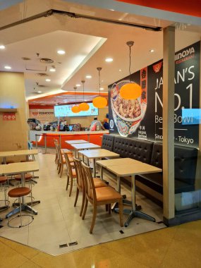 Surabaya - Endonezya, 22 Nisan 2025. Japon atmosferi, modern, ışık oyunu ve ilginç ahşap elementlere sahip Yoshinoya restoranının içi. Göz düzeyi görünümü.