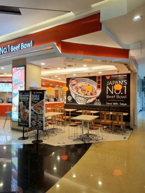 Surabaya - Endonezya, 22 Nisan 2025. Japon atmosferi, modern, ışık oyunu ve ilginç ahşap elementlere sahip Yoshinoya restoranının içi. Göz düzeyi görünümü.