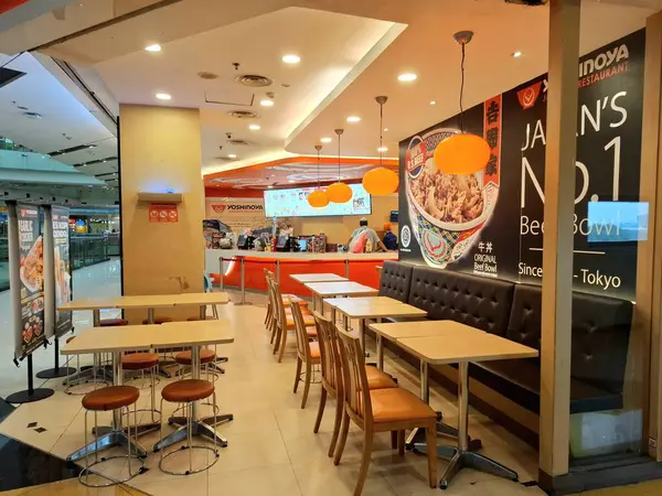 Surabaya - Endonezya, 22 Nisan 2025. Japon atmosferi, modern, ışık oyunu ve ilginç ahşap elementlere sahip Yoshinoya restoranının içi. Göz düzeyi görünümü.