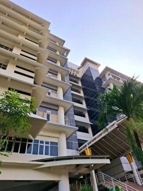 Surabaya - Endonezya, 7 Mayıs 2025. Bir üniversite kampüs binasının dış tasarımı, tropikal yapı kantilatörleri üzerine bir oyun. Sabah göz hizasında..