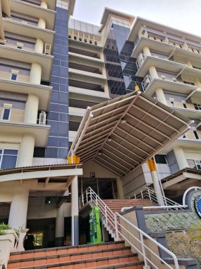 Surabaya - Endonezya, 7 Mayıs 2025. Bir üniversite kampüs binasının dış tasarımı, tropikal yapı kantilatörleri üzerine bir oyun. Sabah göz hizasında..