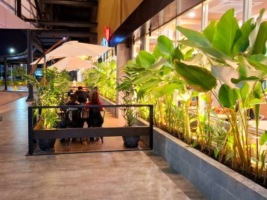 Sidoarjo, Endonezya, 9 Mayıs 2025. Pan & Flip restoranının ön görüntüsü, yemek alanında bitki unsurları barındırıyor, verimli bir atmosfer yaratıyor. Geceleri göz hizası görüntüsü.