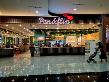 Sidoarjo, Endonezya, 9 Mayıs 2025. Pan & Flip restoranının ön görüntüsü, yemek alanında bitki unsurları barındırıyor, verimli bir atmosfer yaratıyor. Geceleri göz hizası görüntüsü.