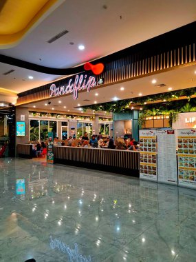 Sidoarjo, Endonezya, 9 Mayıs 2025. Pan & Flip restoranının ön görüntüsü, yemek alanında bitki unsurları barındırıyor, verimli bir atmosfer yaratıyor. Geceleri göz hizası görüntüsü.