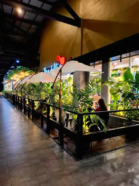 Sidoarjo, Endonezya, 9 Mayıs 2025. Pan & Flip restoranının ön görüntüsü, yemek alanında bitki unsurları barındırıyor, verimli bir atmosfer yaratıyor. Geceleri göz hizası görüntüsü.