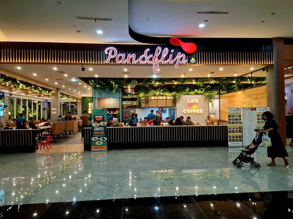 Sidoarjo, Endonezya, 9 Mayıs 2025. Pan & Flip restoranının ön görüntüsü, yemek alanında bitki unsurları barındırıyor, verimli bir atmosfer yaratıyor. Geceleri göz hizası görüntüsü.