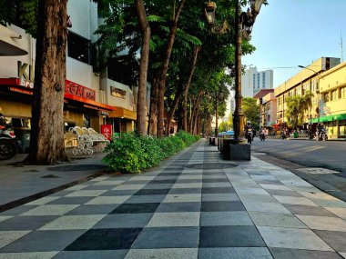 Surabaya - Endonezya, 11 Haziran 2025. Tunjungan Caddesi 'nin yanında güzel ve temiz bir yaya kaldırımı ve Surabaya' da bir sıra kafe. Düşük seviye görünüm.