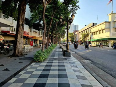 Surabaya - Endonezya, 11 Haziran 2025. Tunjungan Caddesi 'nin yanında güzel ve temiz bir yaya kaldırımı ve Surabaya' da bir sıra kafe. Göz düzeyi görünümü.
