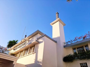 Surabaya - Endonezya, 11 Haziran 2025. Bir otel kulesinde gölgeler oyunu. Binanın kütlesinin derinliğini gösteriyor. Öğleden sonra, düşük göz hizasında..