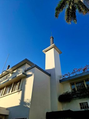 Surabaya - Endonezya, 11 Haziran 2025. Bir otel kulesinde gölgeler oyunu. Binanın kütlesinin derinliğini gösteriyor. Öğleden sonra, düşük göz hizasında..