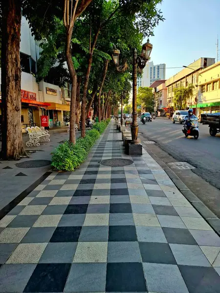 Surabaya - Endonezya, 11 Haziran 2025. Tunjungan Caddesi 'nin yanında güzel ve temiz bir yaya kaldırımı ve Surabaya' da bir sıra kafe. Göz düzeyi görünümü.