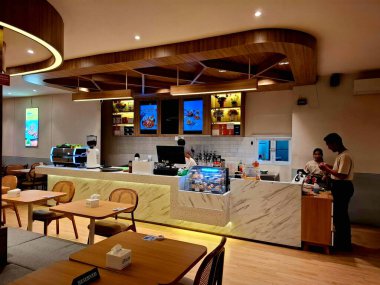 Surabaya, Endonezya, 21 Temmuz 2025. Bir öğrenci kafeteryasının kasası. Güçlü bir ahşap elementi olan çekici bir retro iç tasarım..