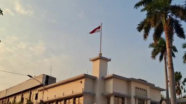 Surabaya, Endonezya, 30 Temmuz 2025. Majapahit Oteli 'nin çatısında kırmızı ve beyaz Endonezya bayrağı dalgalanıyor. Orange Hotel olarak da bilinir. Bu tarihi otel Endonezya Cumhuriyeti 'nin bağımsızlığı mücadelesinde rol oynadı..