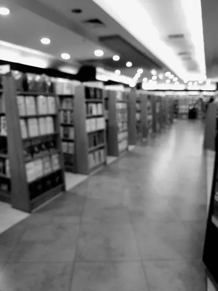 Alışveriş merkezinin içindeki kitapçıların, kırtasiyelerin ve ofis malzemelerinin bulanık ve odaklanmamış fotoğrafları. Siyah beyaz, tek renkli fotoğraf..