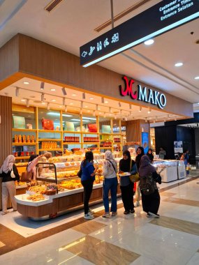 Yogyakarta, Endonezya, 4 Temmuz 2025. Mako kek ve ekmek standının önü. Ekmek ve keklerin sergilendiği dikkat çekici bir vitrin ile bu kabin ziyaretçilerin dikkatini çekiyor. Göz düzeyi görünümü.