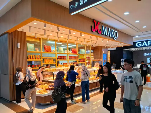 Yogyakarta, Endonezya, 4 Temmuz 2025. Mako kek ve ekmek standının önü. Ekmek ve keklerin sergilendiği dikkat çekici bir vitrin ile bu kabin ziyaretçilerin dikkatini çekiyor. Göz düzeyi görünümü.