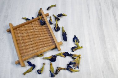 Beyaz arka planda, dağınık anchan çiçekleriyle bambu bardak tutacağı.