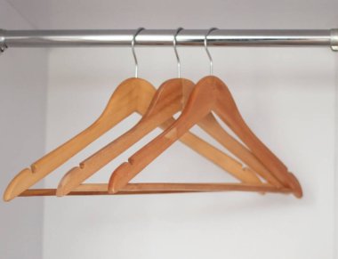 Dolaptaki kıyafetler için üç tahta askı.