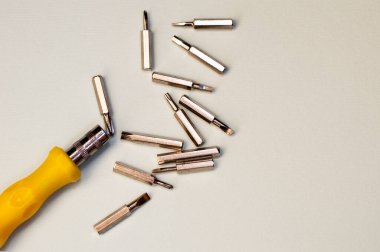 Gri arkaplandaki tornavida ve bitler