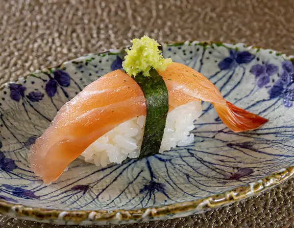 a Japanese sushi dish, one exquisite piece of nigiri, with focus on the fish texture