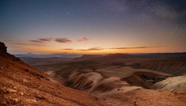 Yıldızlarla dolu bir gökyüzü ile Mars 'a benzeyen manzaranın doğuşunun manzarası..