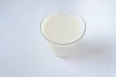 soya sütü beyaz bir zemin üzerinde fotoğraflanmış ve güneşten gelen doğal aydınlatma ile