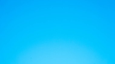 Mavi gökyüzünü gösteren minimalist ve basit bir görüntü. Plajda tipik sakin atmosferi olan ağaçlar.