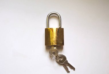 Fotoğrafta demir ve metalden yapılmış asma kilit tuşları beyaz arka planda.