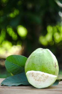 Dilimlenmiş guava meyvesi, dilimlenmiş ahşap masa arkaplanındaki guava dilimleri. 