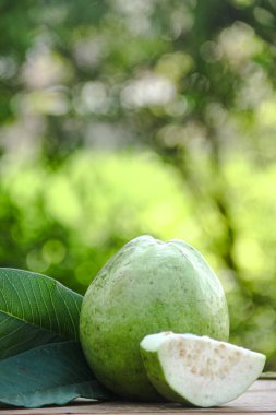 Dilimlenmiş guava meyvesi, dilimlenmiş ahşap masa arkaplanındaki guava dilimleri. 