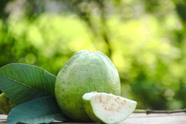 Dilimlenmiş guava meyvesi, dilimlenmiş ahşap masa arkaplanındaki guava dilimleri. 