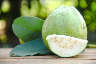 Dilimlenmiş guava meyvesi, dilimlenmiş ahşap masa arkaplanındaki guava dilimleri. 