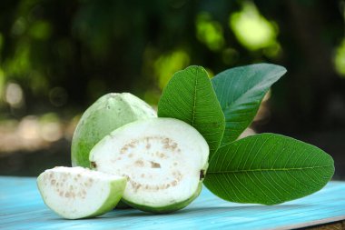 Dilimlenmiş guava meyvesi, dilimlenmiş ahşap masa arkaplanındaki guava dilimleri. 