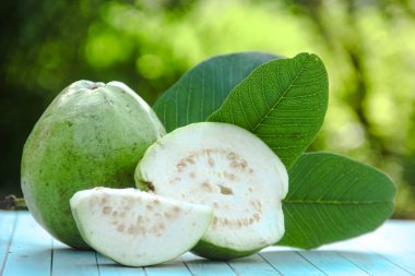 Dilimlenmiş guava meyvesi, dilimlenmiş ahşap masa arkaplanındaki guava dilimleri. 