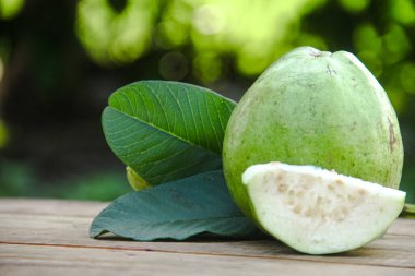 Dilimlenmiş guava meyvesi, dilimlenmiş ahşap masa arkaplanındaki guava dilimleri. 