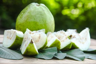Dilimlenmiş guava meyvesi, dilimlenmiş ahşap masa arkaplanındaki guava dilimleri. 