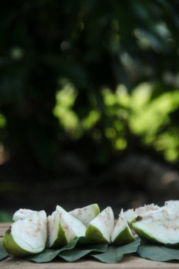 Dilimlenmiş guava meyvesi, dilimlenmiş ahşap masa arkaplanındaki guava dilimleri. 