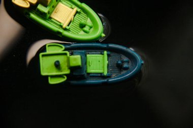 Plastikten yapılmış minyatür balıkçı teknesi ve karanlık sularda yelken açmak.