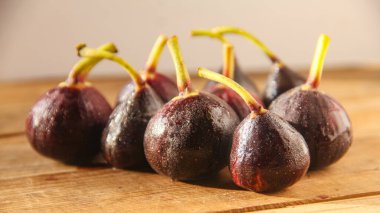 Ahşap bir masada taze mor incirler.