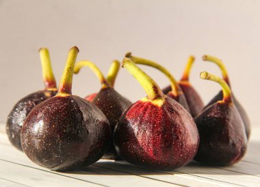 Taze ve doğranmış incirler beyaz arka planda izole edilmiş.