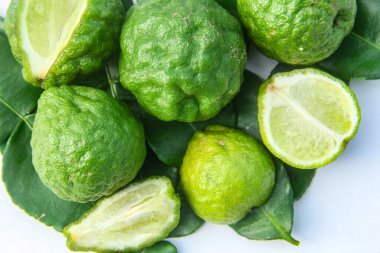 Citrus hystrix veya kaffir limonu veya bergamot dilimlenmiş meyve ve yaprakları beyaz arka planda izole.