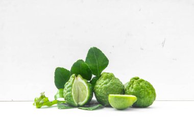 Citrus hystrix veya kaffir limonu veya bergamot dilimlenmiş meyve ve yaprakları beyaz arka planda izole.