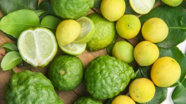 Yapraklar üzerinde kaffir limon ve limon yığını veya sıralanmış Citrus aurantifolia  