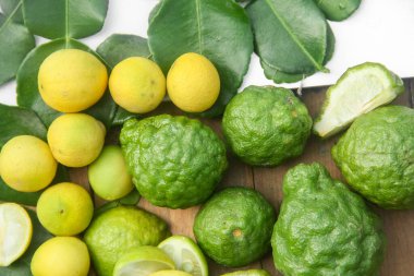 Yapraklar üzerinde kaffir limon ve limon yığını veya sıralanmış Citrus aurantifolia  