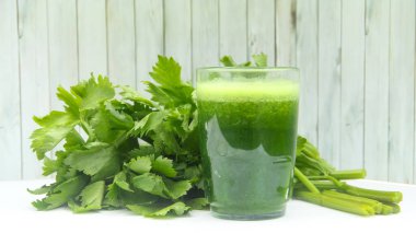 Kereviz suyu, kerevizden yapılmış sağlıklı yeşil içecek taze yeşil kereviz yapraklarıyla süslenmiş yeşil kereviz suyu.