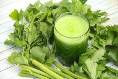 Kereviz suyu, kerevizden yapılmış sağlıklı yeşil içecek taze yeşil kereviz yapraklarıyla süslenmiş yeşil kereviz suyu.