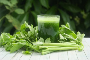 Kereviz suyu, kerevizden yapılmış sağlıklı yeşil içecek taze yeşil kereviz yapraklarıyla süslenmiş yeşil kereviz suyu.